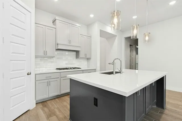 a kitchen with a sink a stove a refrigerator and white cabinets