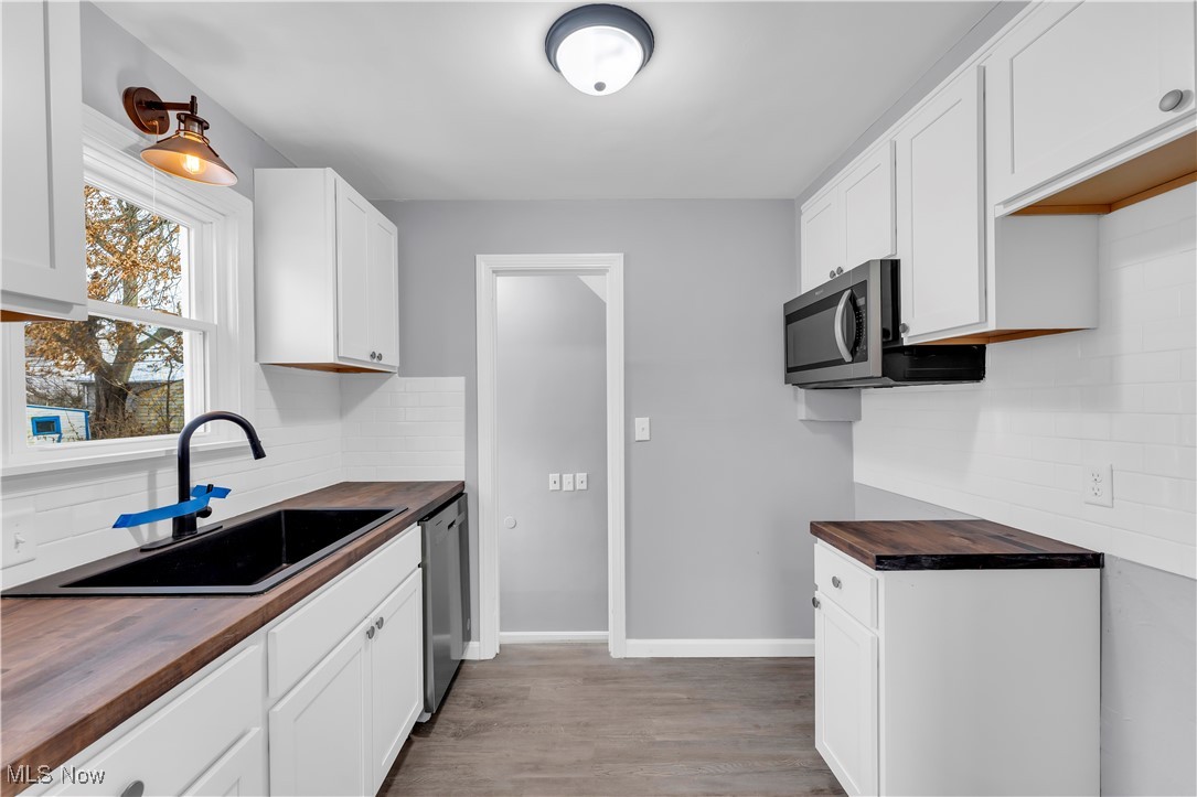 953 Whitby Road Cleveland Heights, OH 44112 - Photo 11 of 27 Kitchen featuring wooden counters, white cabinetry, light wood-style floors, and decorative backsplash