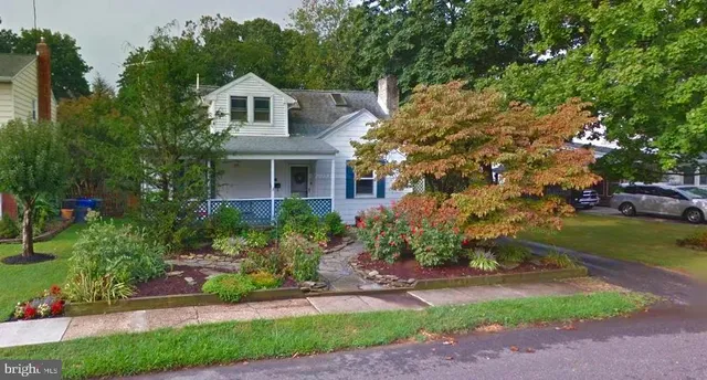 a front view of a house with a garden and plants