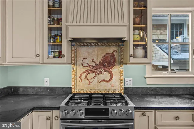 a kitchen with granite countertop a center island stainless steel appliances cabinets and a window