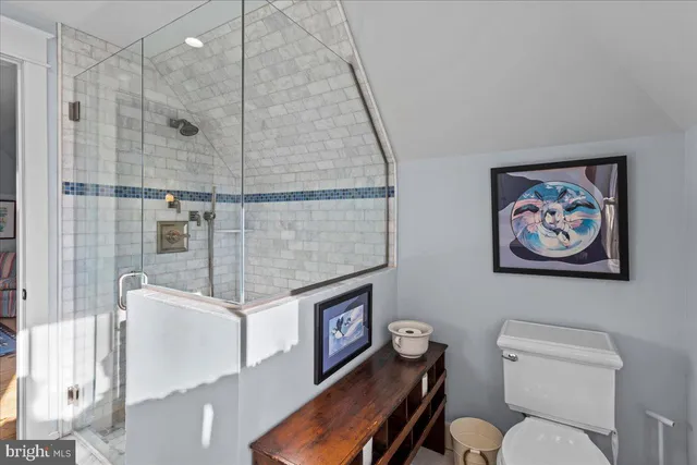 a bathroom with a granite countertop sink a toilet a mirror and shower