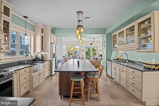 a kitchen with stainless steel appliances granite countertop a stove top oven a sink a counter space and dining table