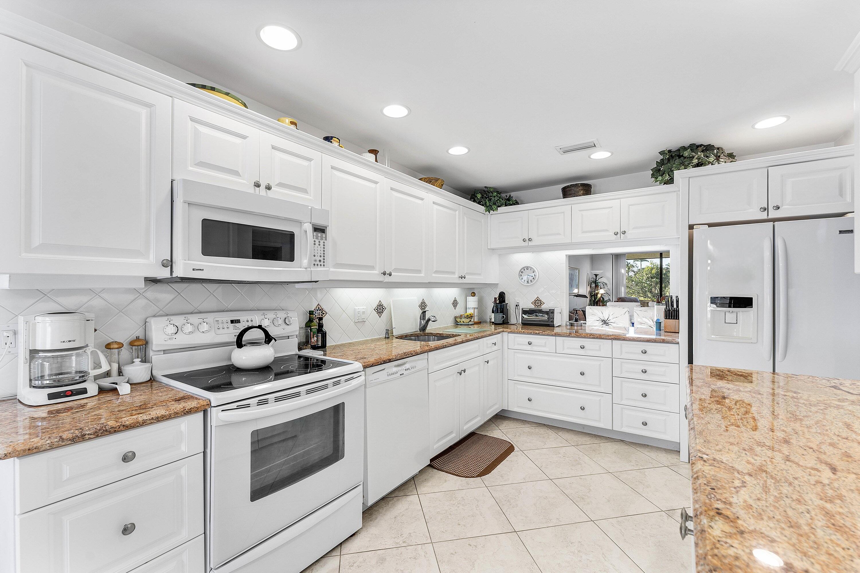 61 Eastgate Drive, Unit A Boynton Beach, FL 33436 - Photo 16 of 54 a kitchen with stainless steel appliances granite countertop white cabinets sink and white appliances