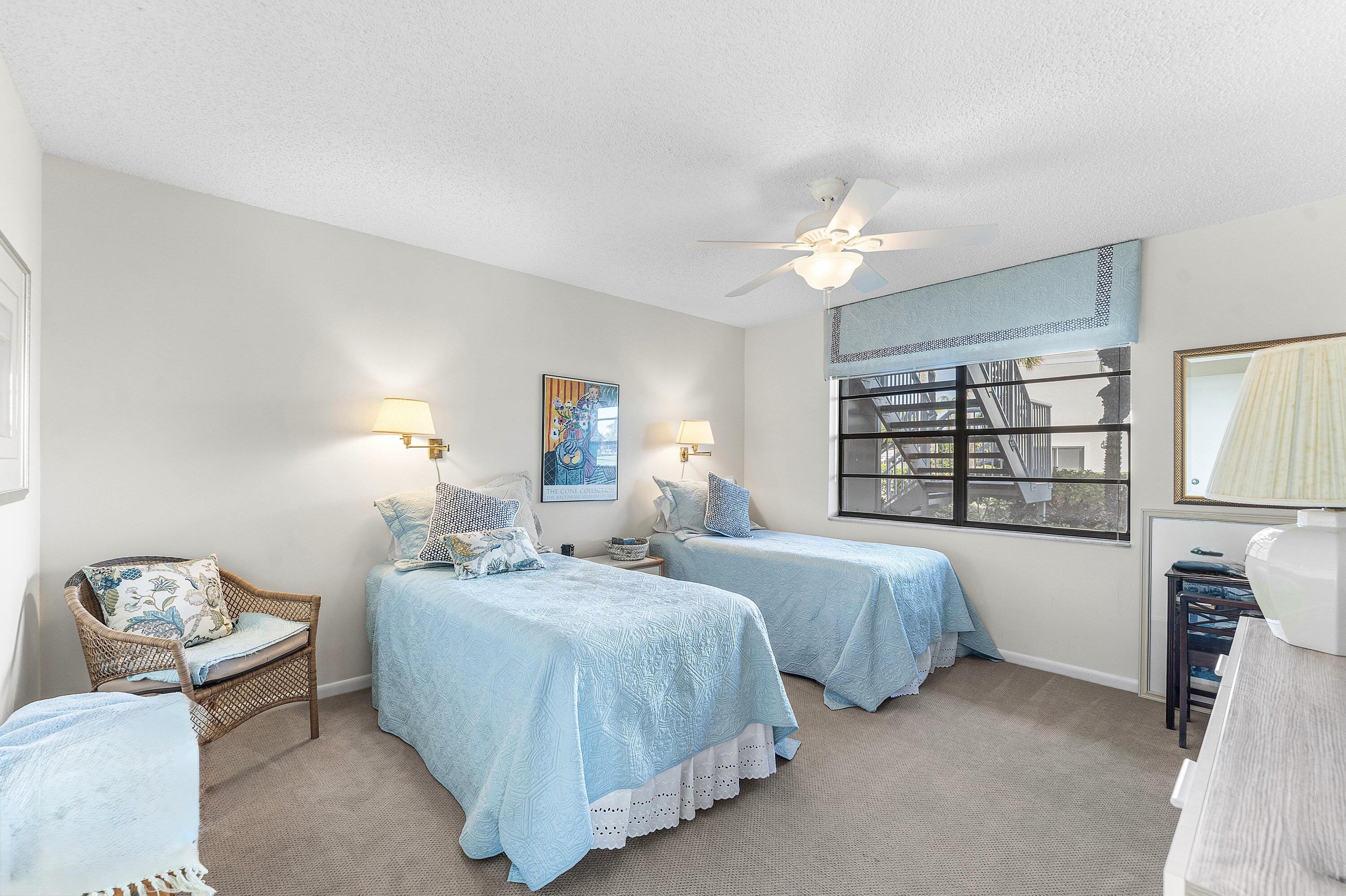 61 Eastgate Drive, Unit A Boynton Beach, FL 33436 - Photo 21 of 54 a bedroom with two beds and a chandelier
