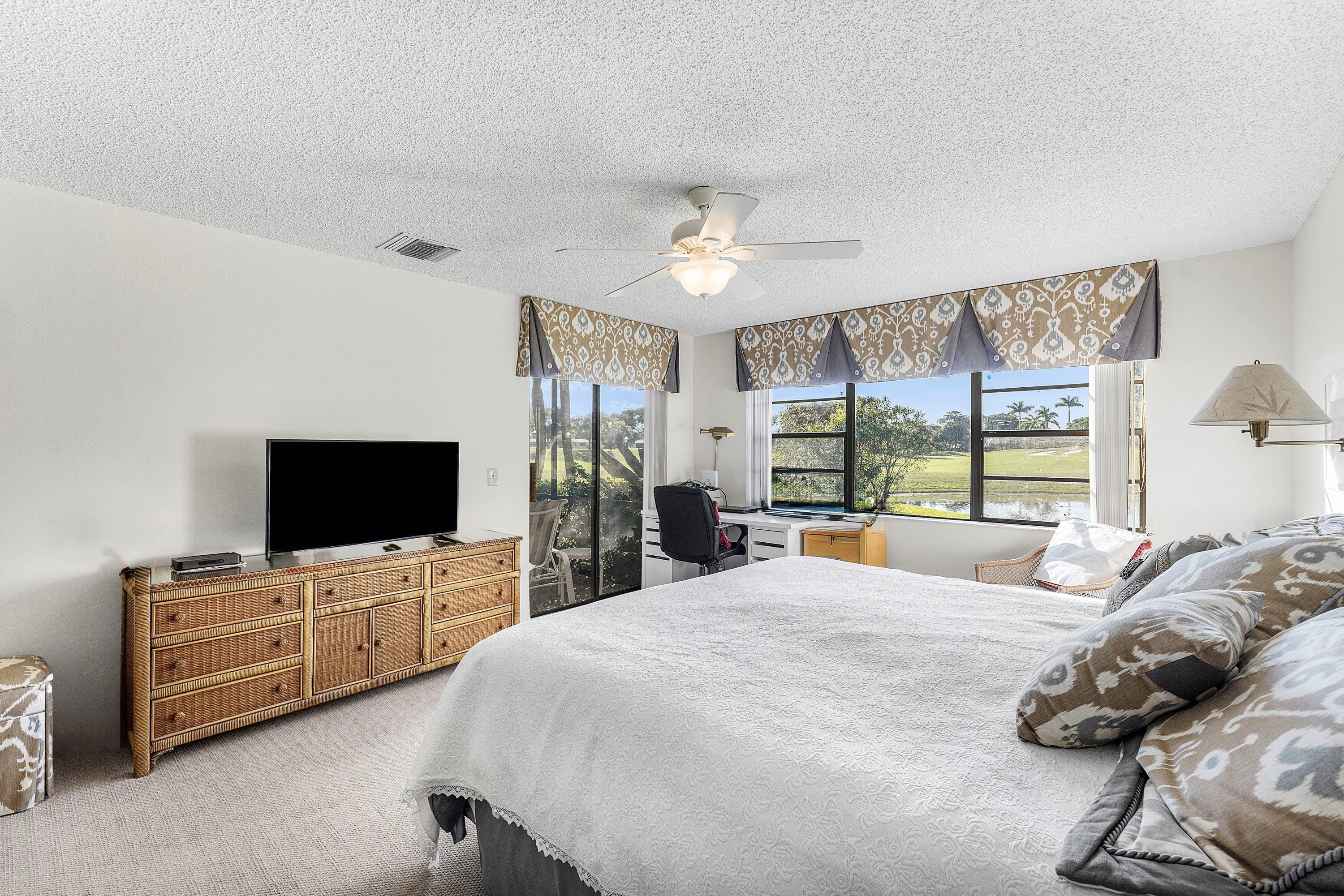 61 Eastgate Drive, Unit A Boynton Beach, FL 33436 - Photo 23 of 54 a large bedroom with bed and tv
