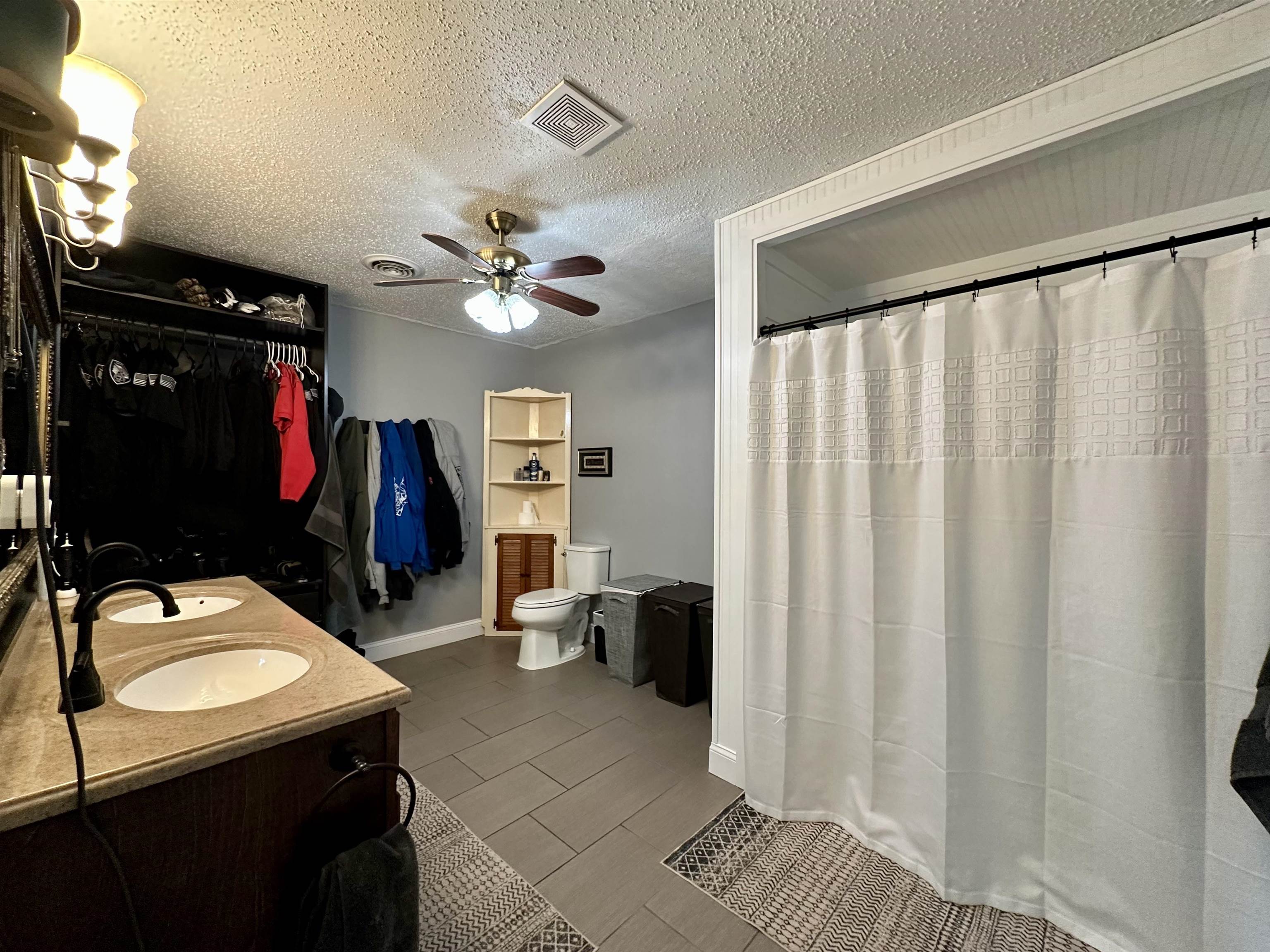 1230 Joann Road Somerville, TN 38068 - Photo 12 of 28 Full bath with double vanity, ceiling fan, a textured ceiling, and a shower with curtain