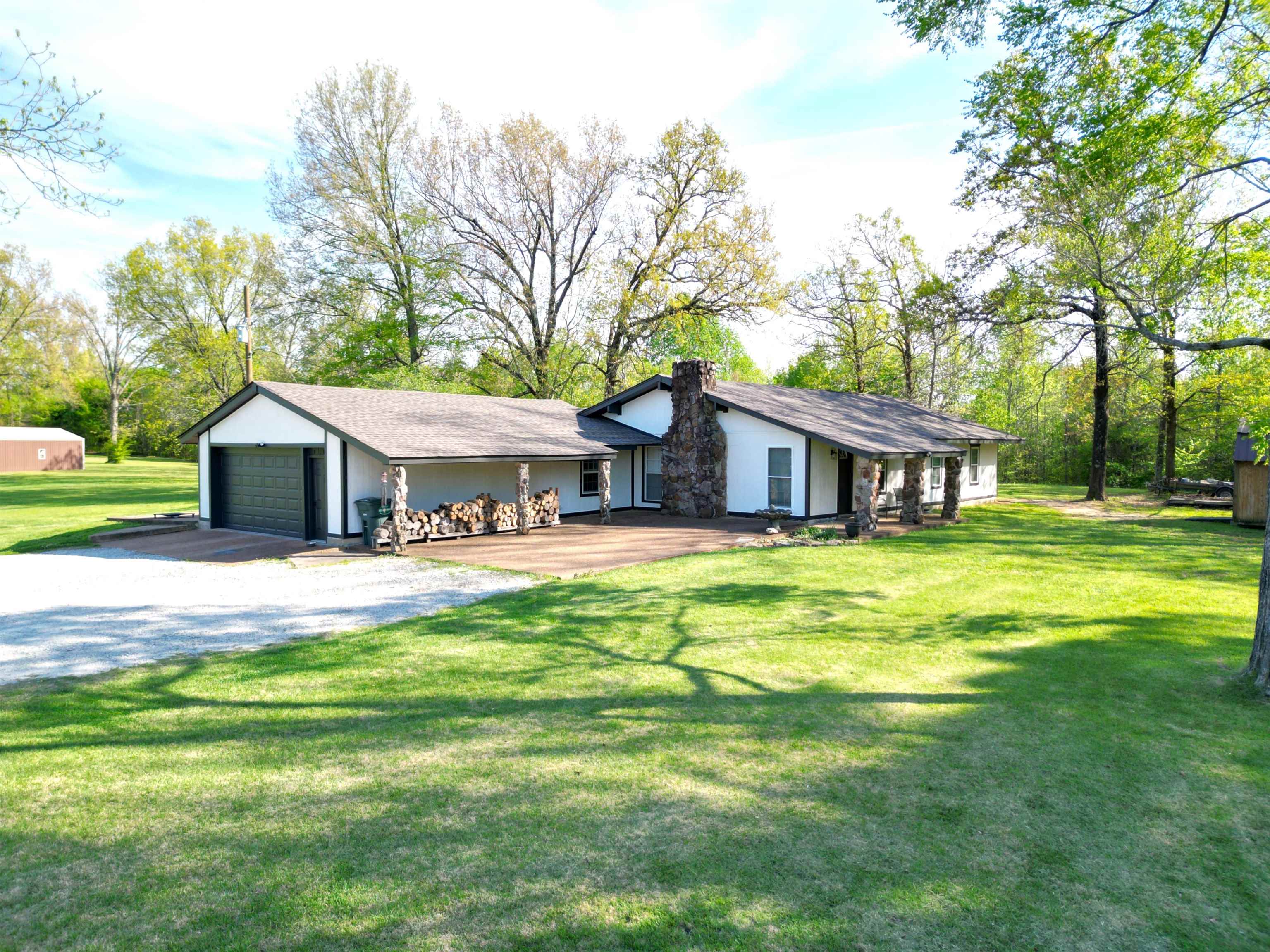 1230 Joann Road Somerville, TN 38068 - Photo 27 of 28 View of front facade featuring a front yard, a garage, a chimney, driveway, and a porch
