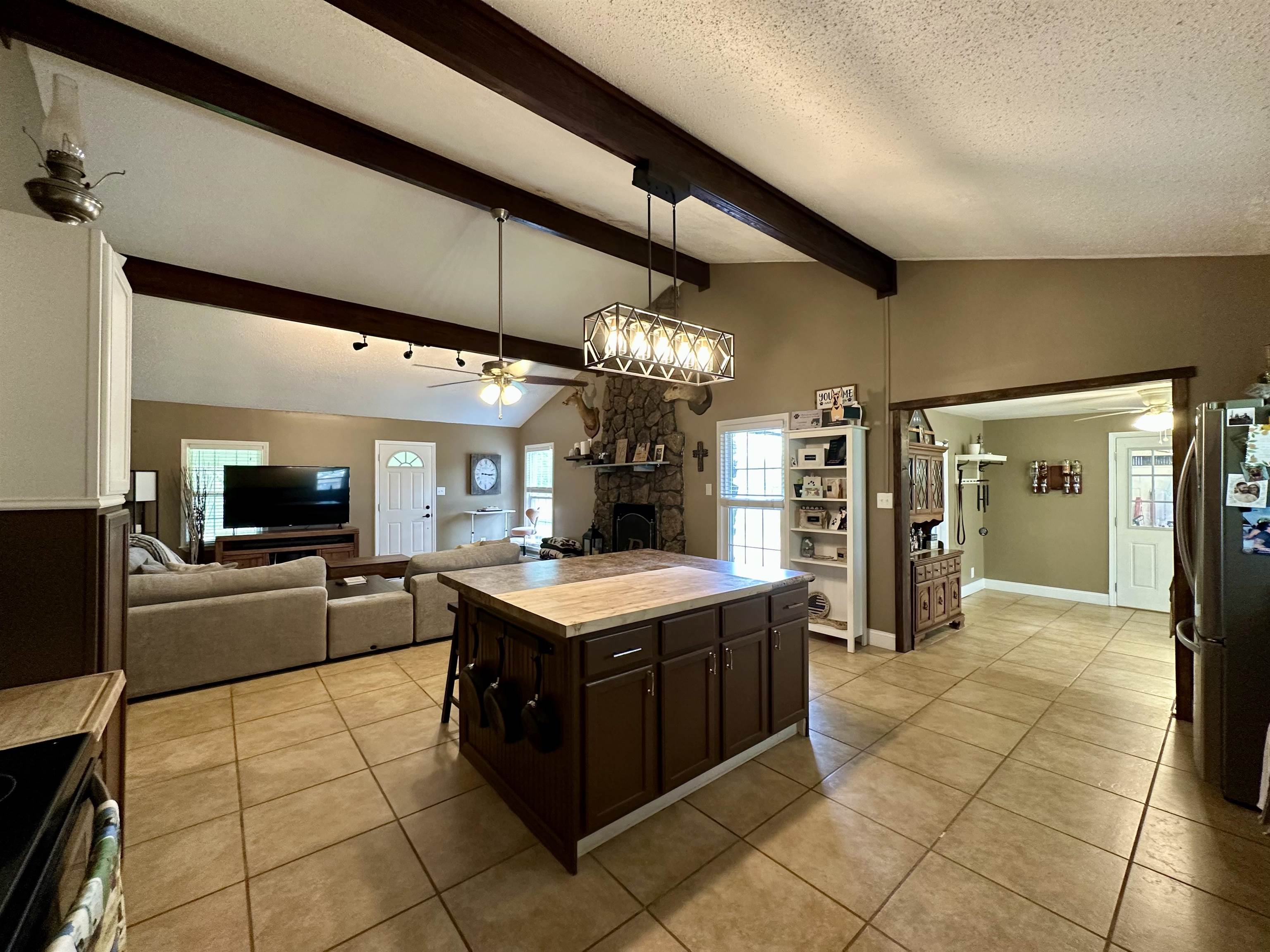 1230 Joann Road Somerville, TN 38068 - Photo 28 of 28 Kitchen with dark wood finish cabinets, open floor plan, decorative light fixtures, black range with electric stovetop, and freestanding refrigerator