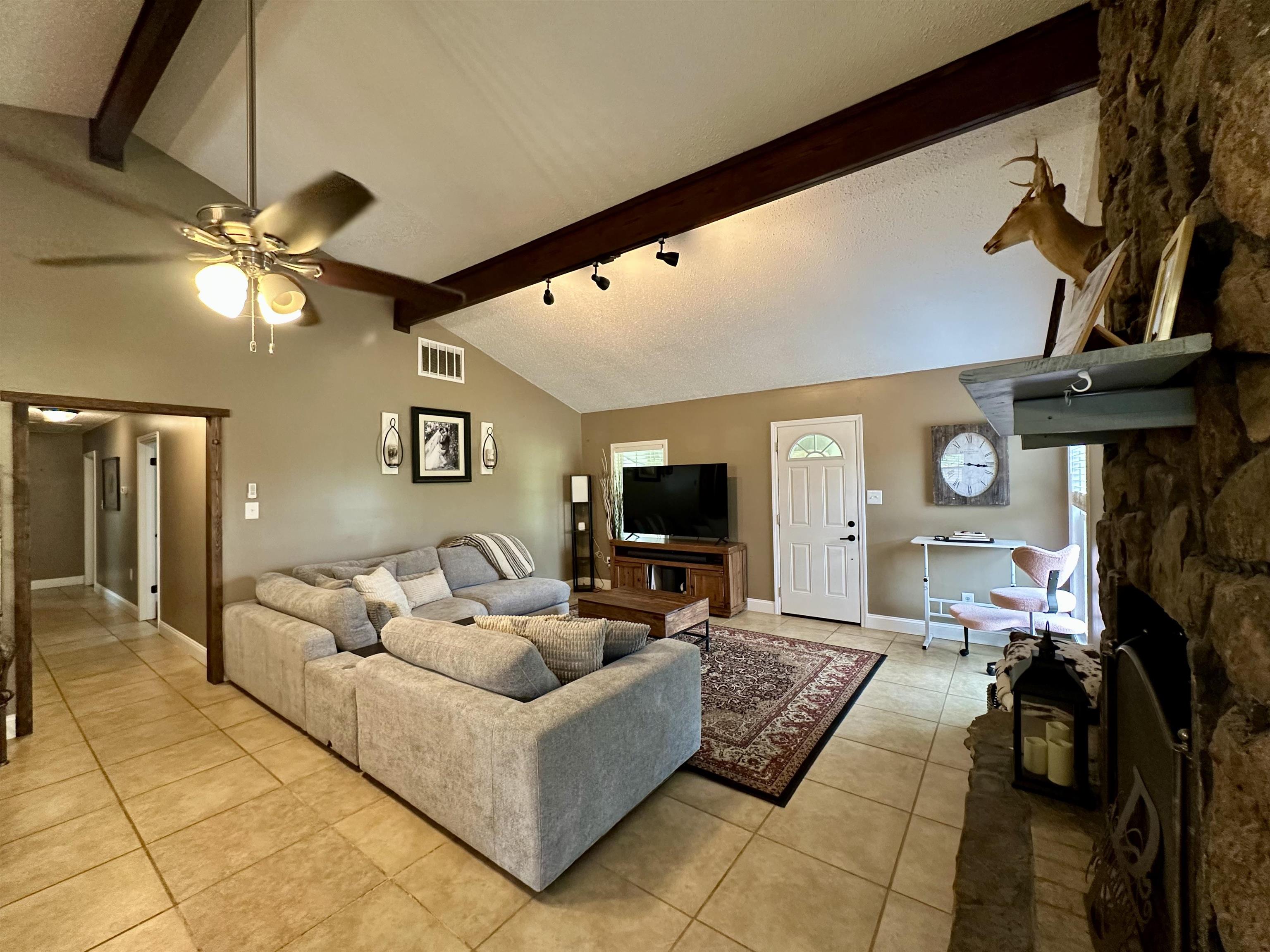1230 Joann Road Somerville, TN 38068 - Photo 9 of 28 Living area with a stone fireplace, light tile patterned floors, and a ceiling fan