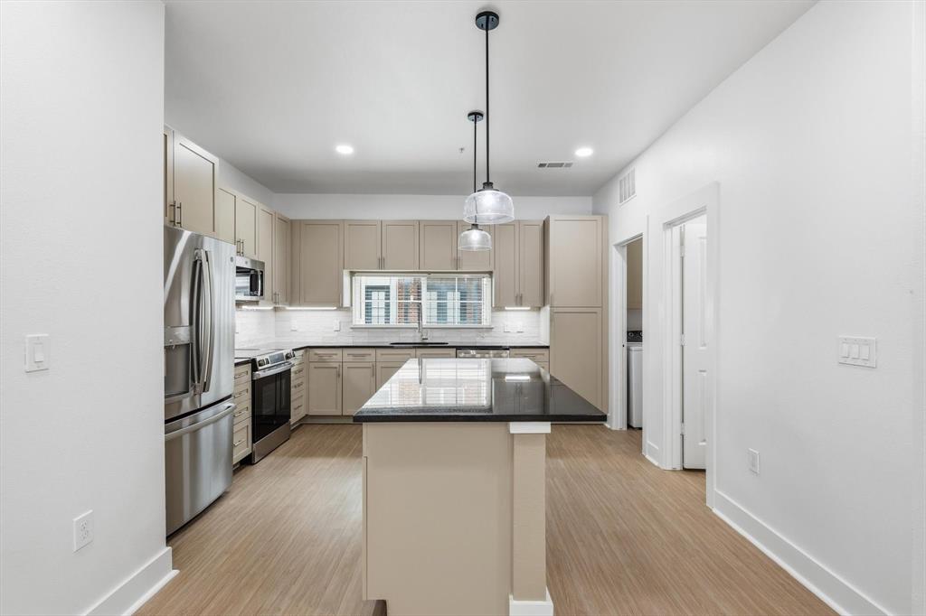 4110 Fairmount Street, Unit 1004 Dallas, TX 75219 - Photo 9 of 35 a kitchen with kitchen island a counter top space stainless steel appliances and a refrigerator