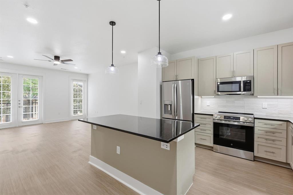 4110 Fairmount Street, Unit 1004 Dallas, TX 75219 - Photo 10 of 35 a kitchen with stainless steel appliances granite countertop a refrigerator a stove a sink and a microwave