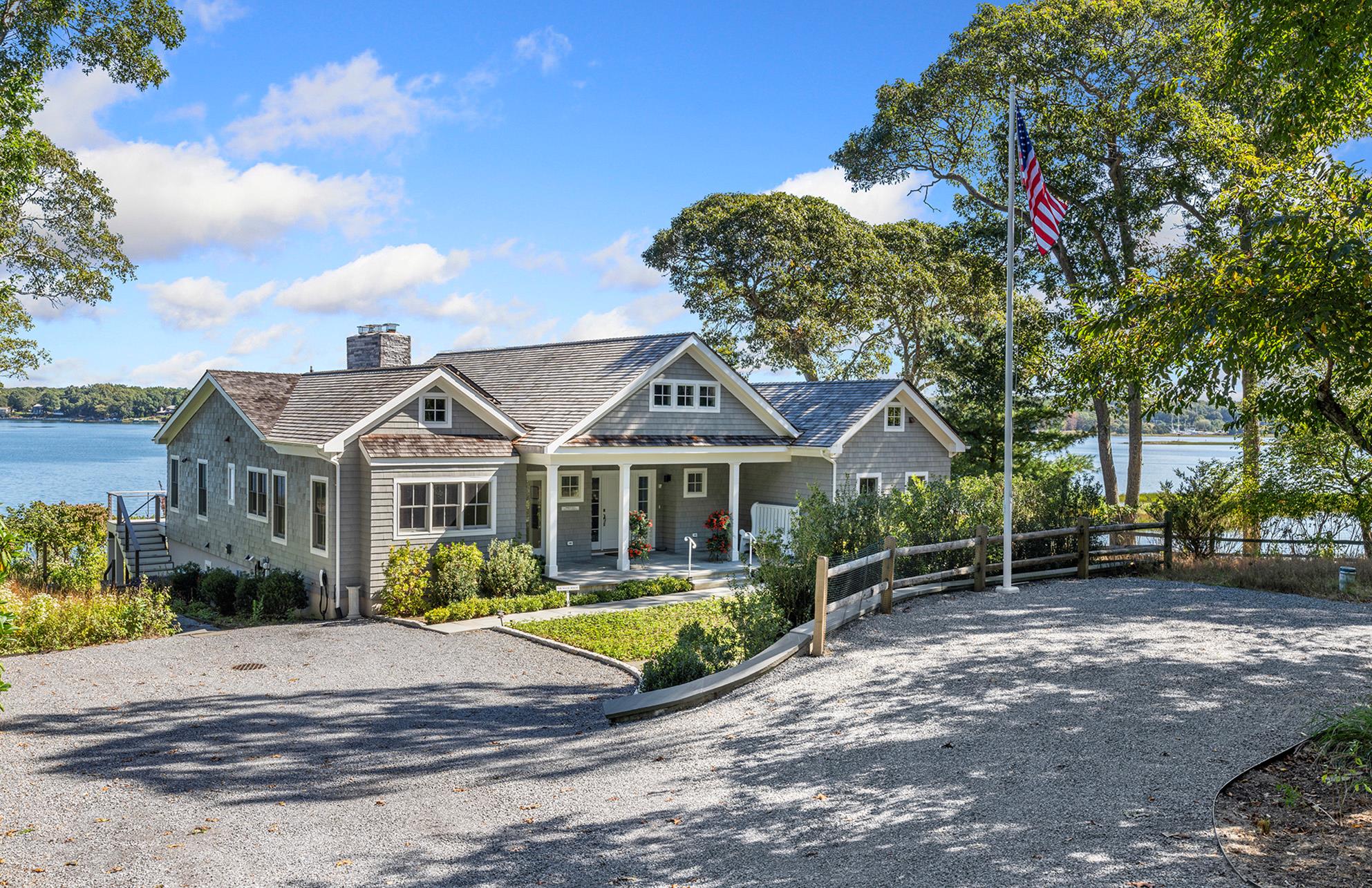 a view of a house with a big yard and large trees