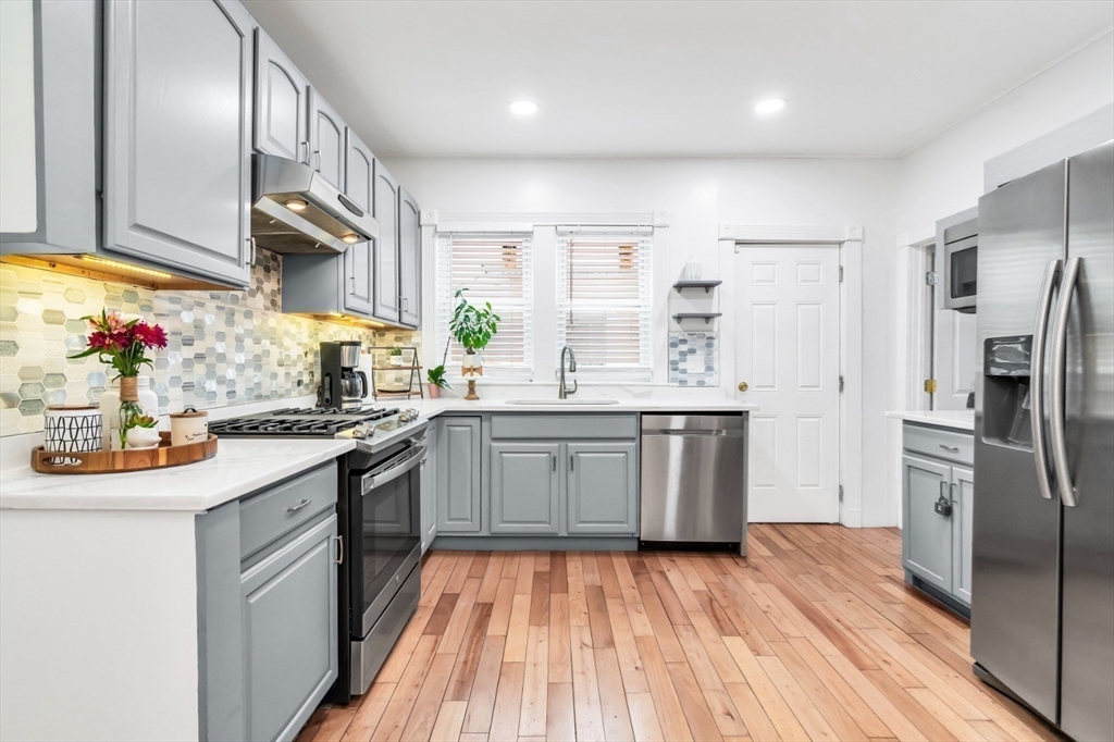 42 D Street Lowell, MA 01851 - Photo 13 of 27 a kitchen with stainless steel appliances a sink dishwasher a refrigerator and a stove with wooden floor