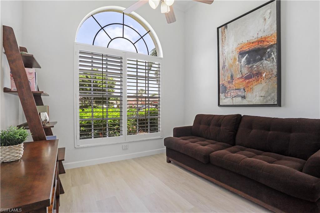 7699 Groves Road Naples, FL 34109 - Photo 15 of 30 a living room with furniture and a large window