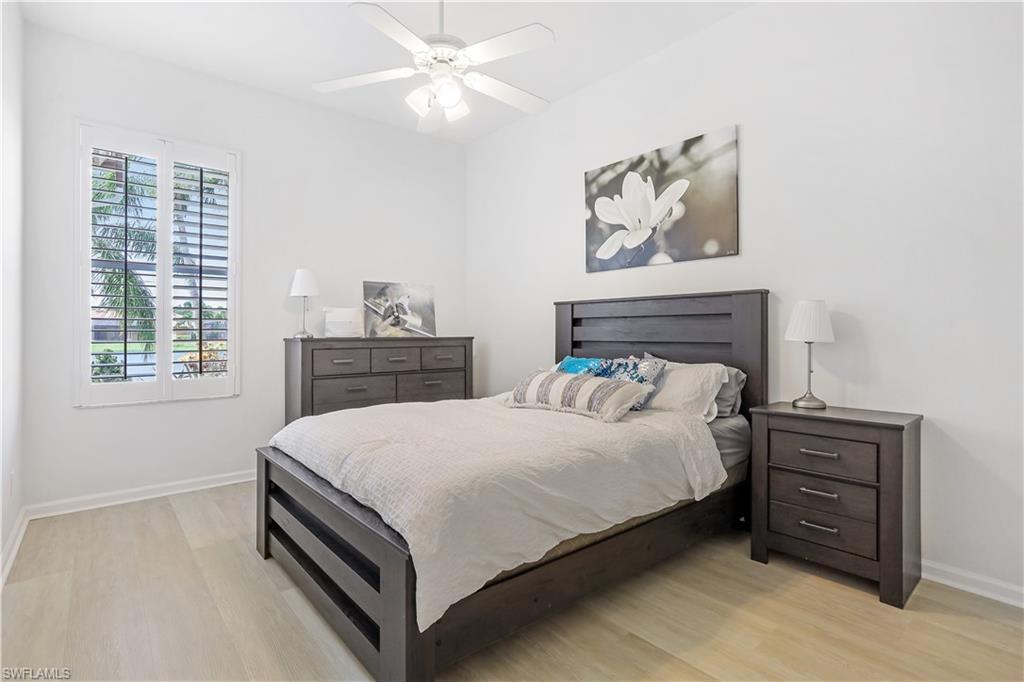 7699 Groves Road Naples, FL 34109 - Photo 23 of 30 a bedroom with a bed and a table