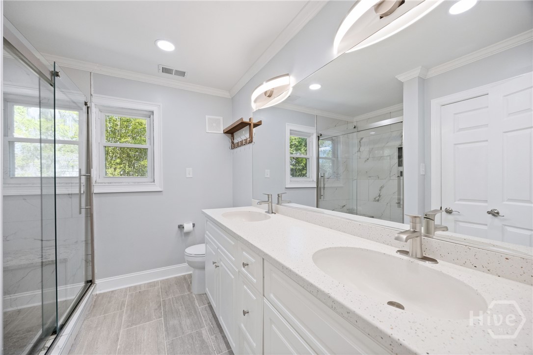 95 Circle Drive Midway, GA 31320 - Photo 12 of 29 Updated bathroom with dual vanities, clean finishes, and a spacious glass shower