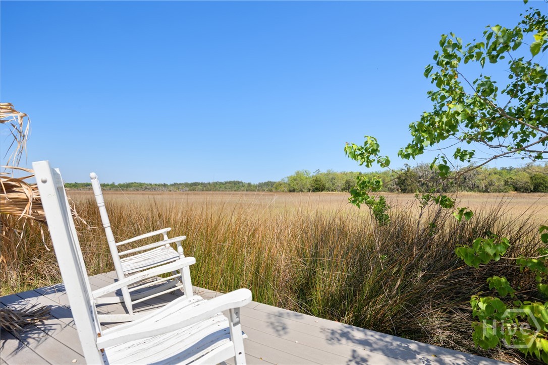 95 Circle Drive Midway, GA 31320 - Photo 23 of 29 Peaceful marshfront setting viewed from a private deck with classic rocking chairs—perfect for enjoying serene water and wildlife views.