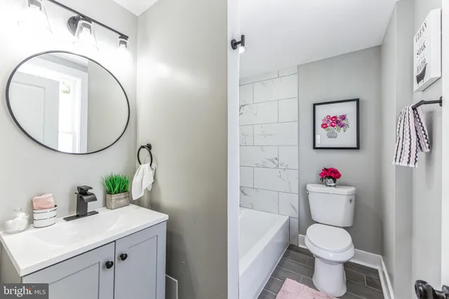 a bathroom with a sink a toilet and a mirror