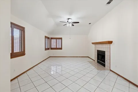 an empty room with windows and fireplace