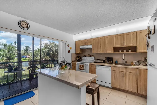 a kitchen with a stove a sink a refrigerator and cabinets