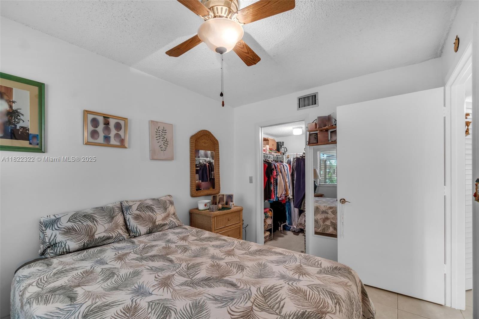 17000 Northwest 67th Avenue, Unit 126 Hialeah, FL 33015 - Photo 11 of 25 a bedroom with a large bed and a ceiling fan