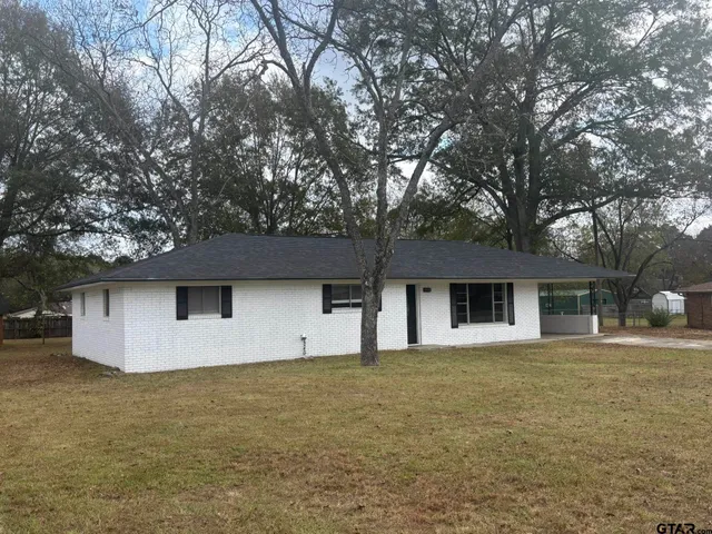 a front view of house with yard and trees