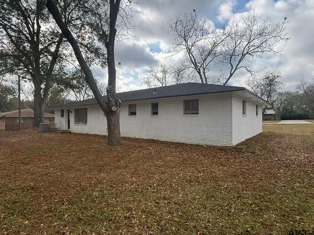 a backyard of a house with large trees