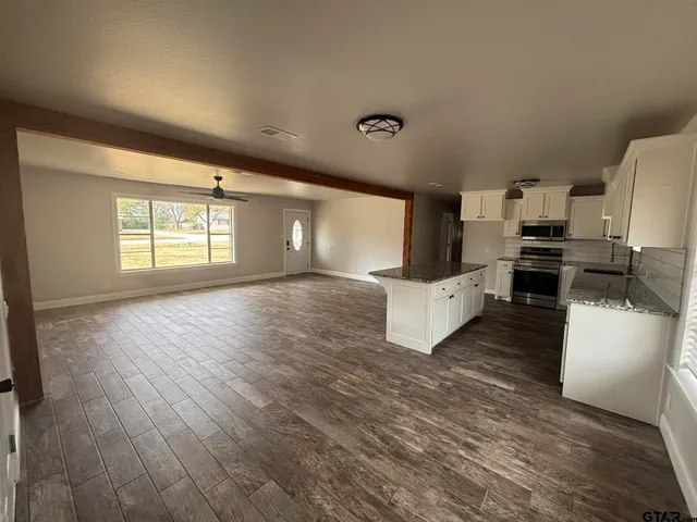 a view of a kitchen with wooden floor and electronic appliances