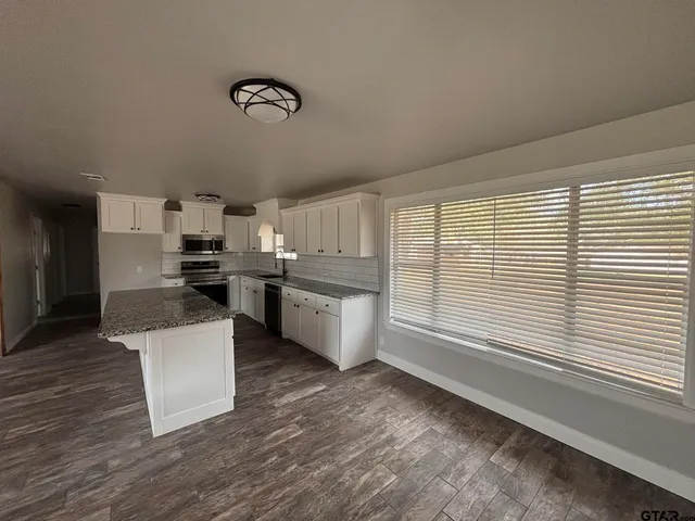 a kitchen with a refrigerator and white cabinets