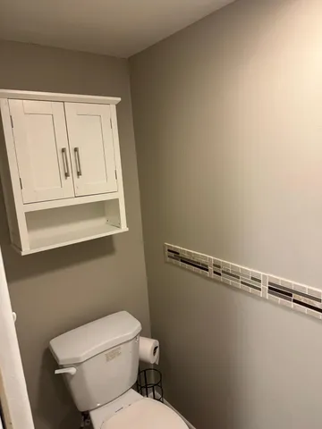 a white toilet sitting next to a window