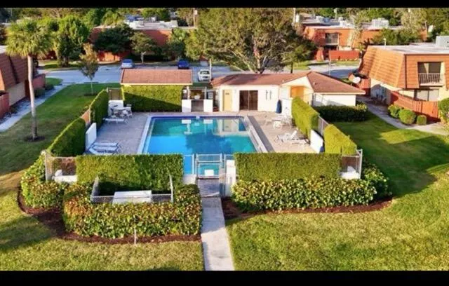 an aerial view of a house with a garden and lake view