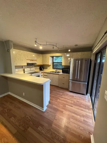 a large kitchen with stainless steel appliances granite countertop a stove a sink dishwasher and a refrigerator
