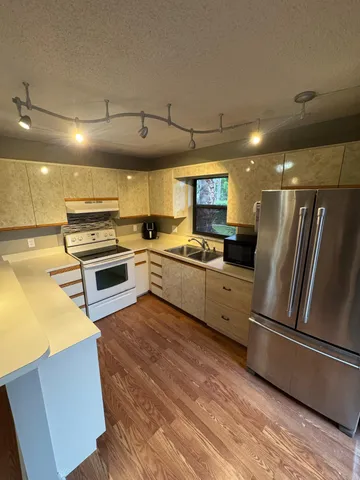 a kitchen with stainless steel appliances a refrigerator sink and stove