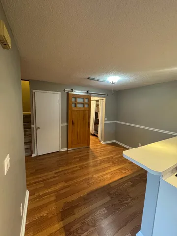 a view of an empty room with wooden floor