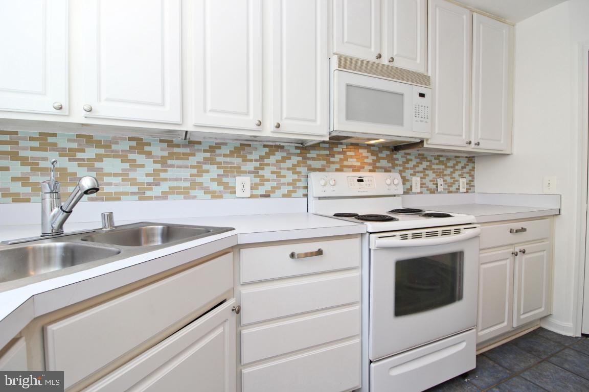 656 Luthardt Road Baltimore, MD 21220 - Photo 12 of 27 a kitchen with granite countertop white cabinets and white appliances