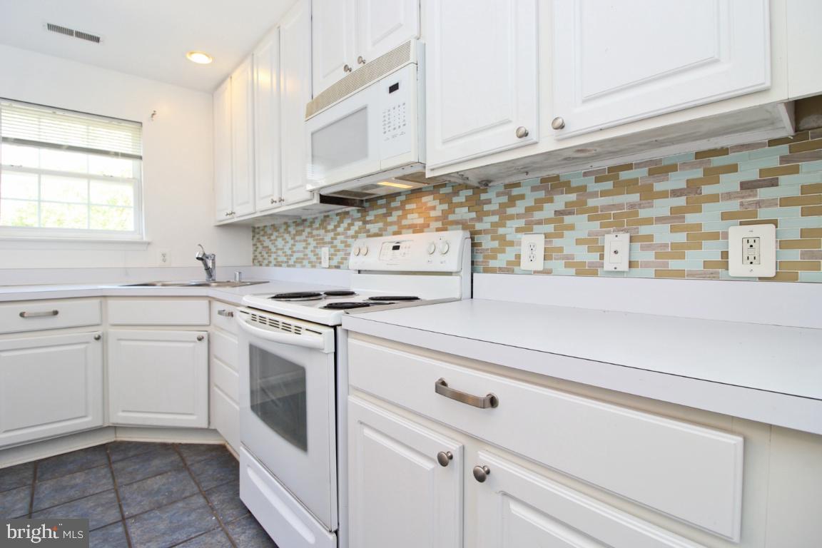 656 Luthardt Road Baltimore, MD 21220 - Photo 13 of 27 a kitchen with white cabinets stainless steel appliances and sink