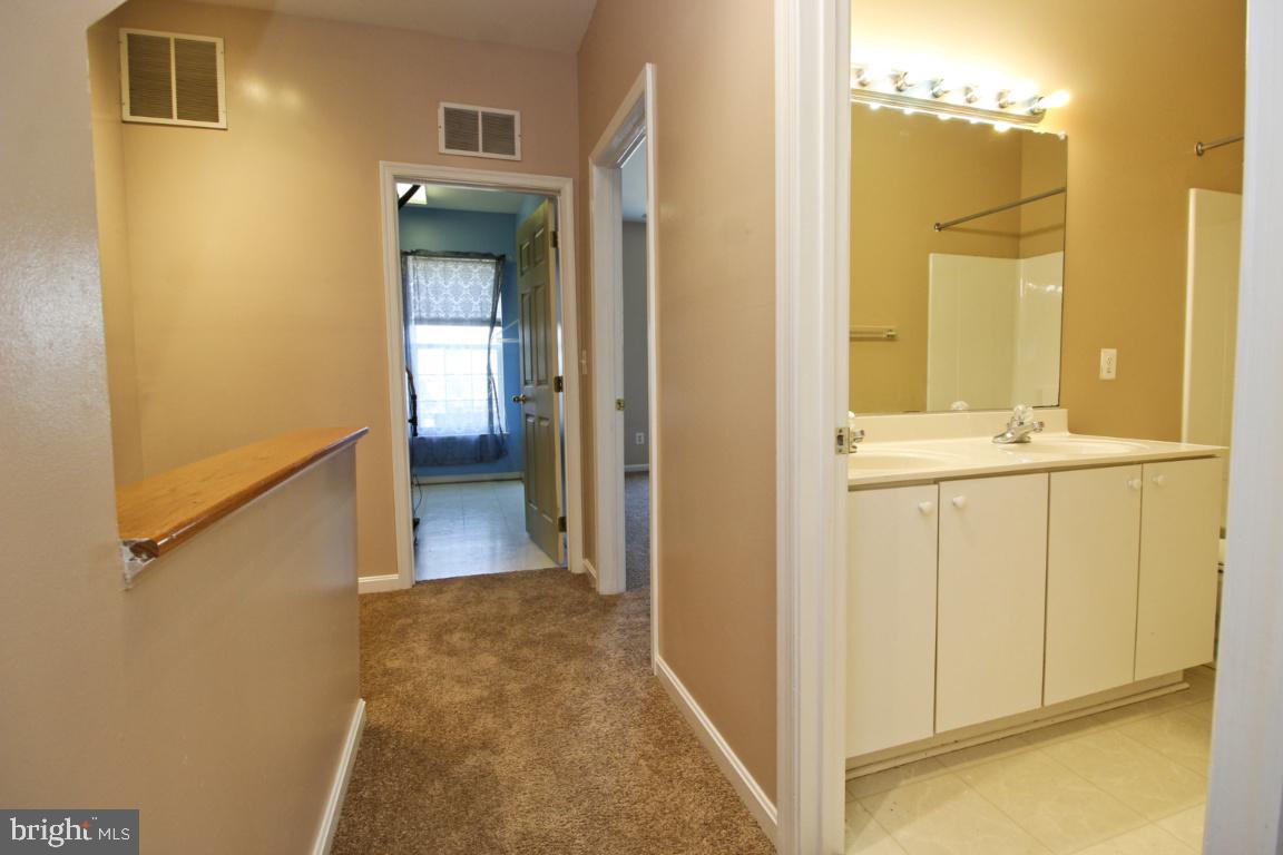 656 Luthardt Road Baltimore, MD 21220 - Photo 14 of 27 a view of a hallway with wooden floor and a bathroom
