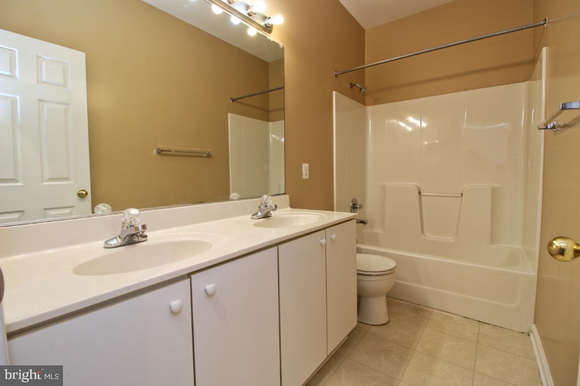 656 Luthardt Road Baltimore, MD 21220 - Photo 15 of 27 a bathroom with a double vanity sink toilet and shower
