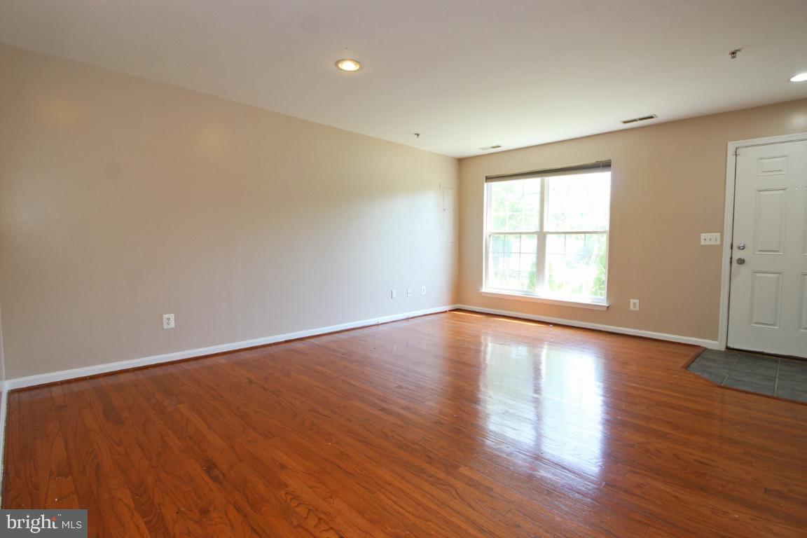656 Luthardt Road Baltimore, MD 21220 - Photo 5 of 27 an empty room with wooden floor and windows