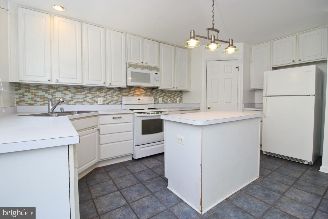 656 Luthardt Road Baltimore, MD 21220 - Photo 10 of 27 a kitchen with a sink a stove a refrigerator and cabinets