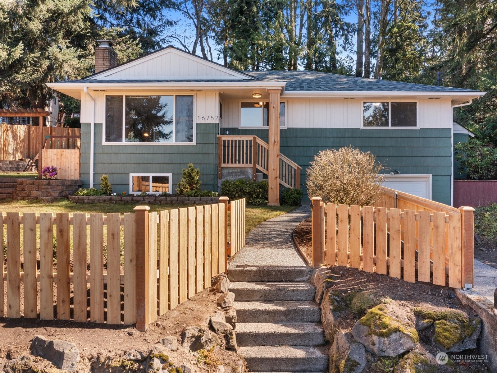 a front view of a house with large trees