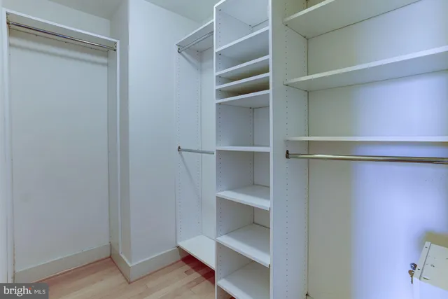 a view of walk in closet with empty racks