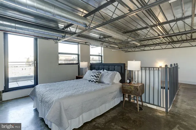 a bedroom with a bed next to a window