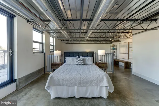 a spacious bedroom with a bed next to a window