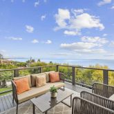 a balcony with wooden floor and outdoor seating