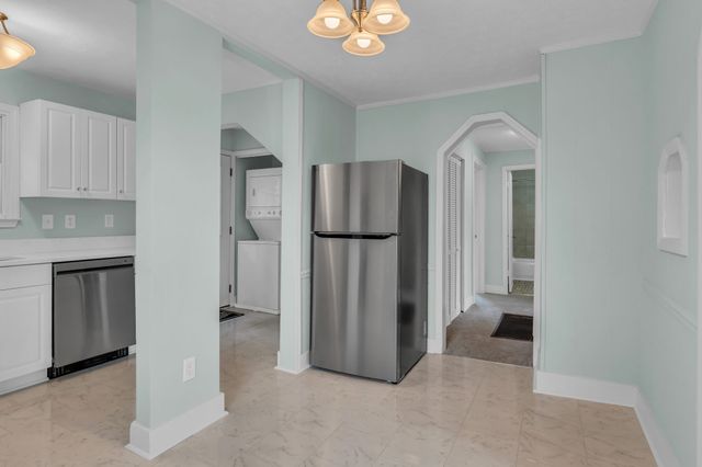 a view of a kitchen with a refrigerator and cabinets