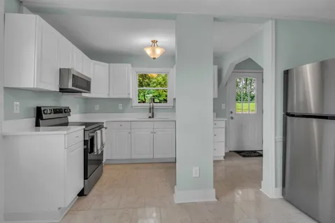 a kitchen with a refrigerator a stove a microwave and cabinets