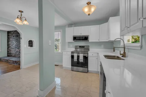 a kitchen with kitchen island a stove a sink and a refrigerator