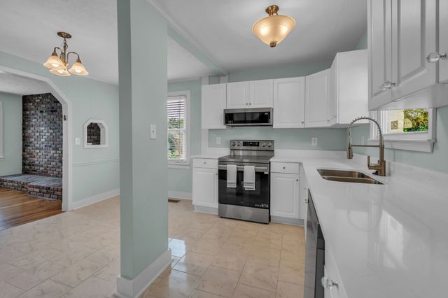 a kitchen with kitchen island a stove a sink and a refrigerator