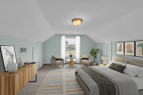 a large bedroom with a bed and wooden floor